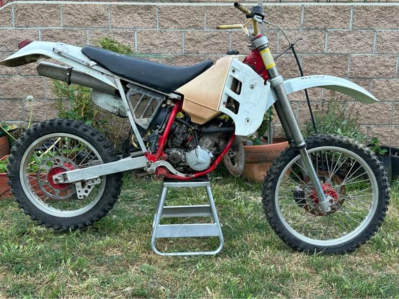 A dirt bike parked on a ladder

Description automatically generated